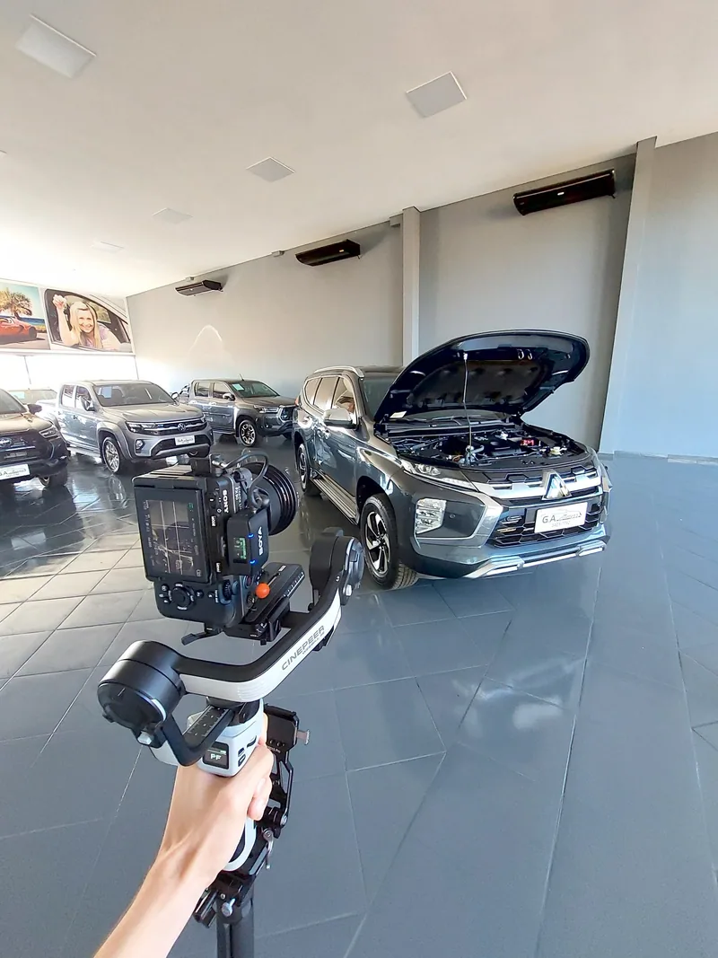 Câmera em gimbal diante de carros em uma loja de veículos