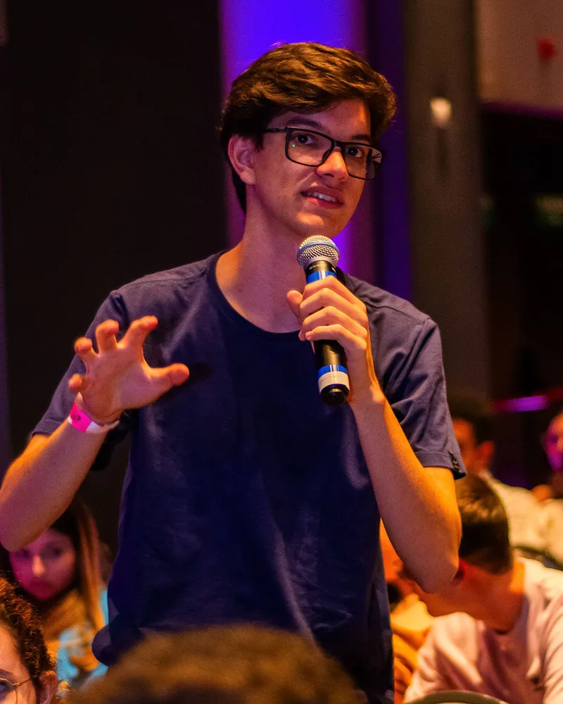 Pessoa de pé falando ao microfone durante um evento